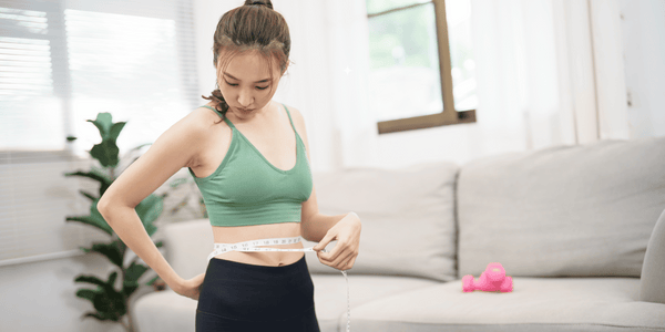 A girl measuring her waist